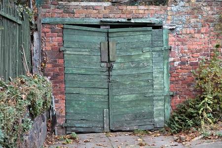 68090899-vintage-wooden-garage-doors-green-old-timber-garage-gate-on-red-brick-wall-.jpg